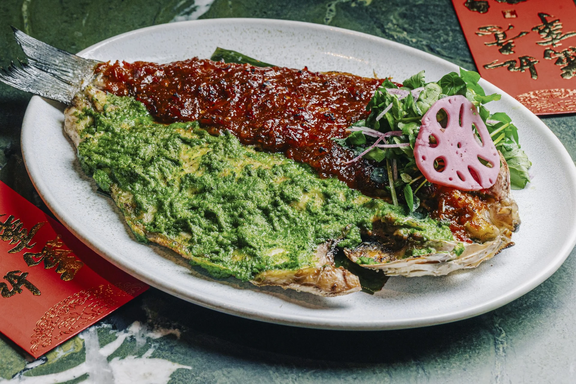 Poisson entier poêlé avec sauce sambal rouge et garniture verte