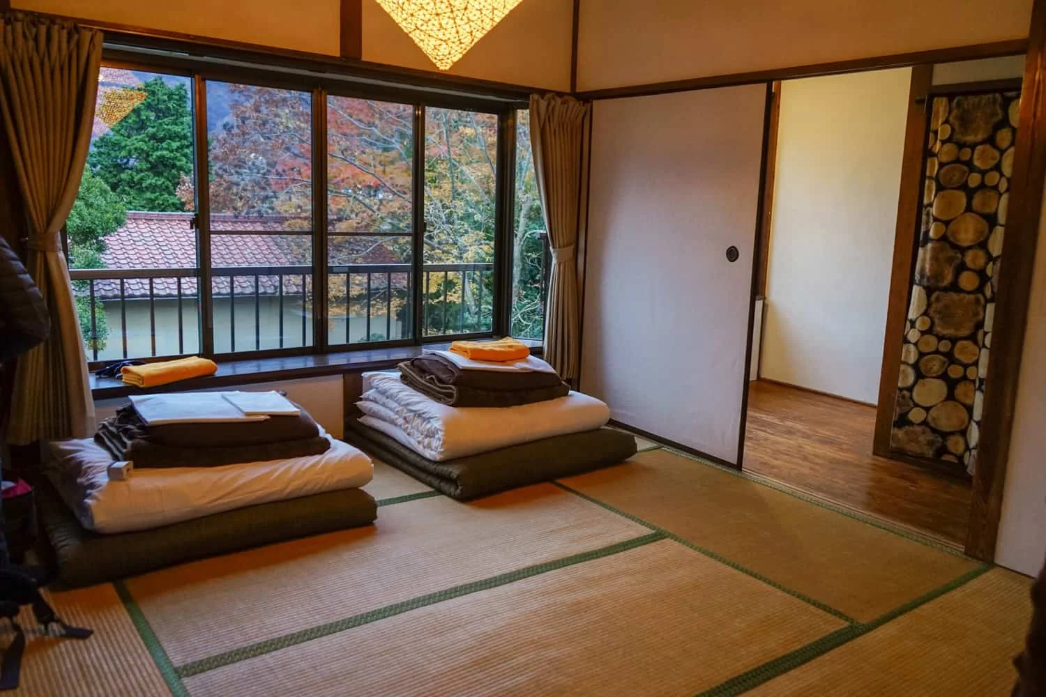 Chambre traditionnelle japonaise avec sol en tatami, futons et table basse dans un Ryokan à Hakone