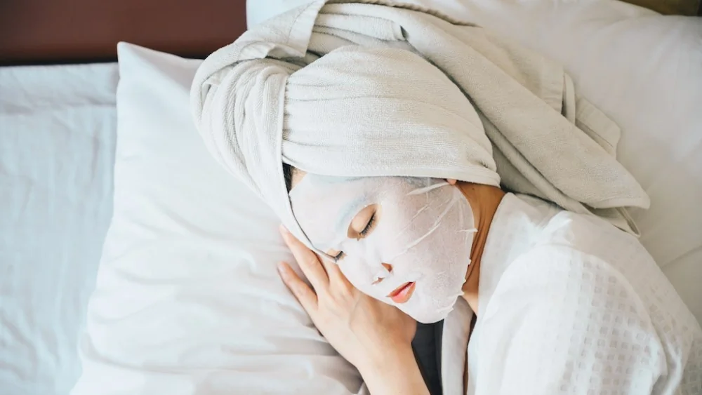 Application d'un masque de nuit coréen hydratant pour une peau repulpée au réveil.