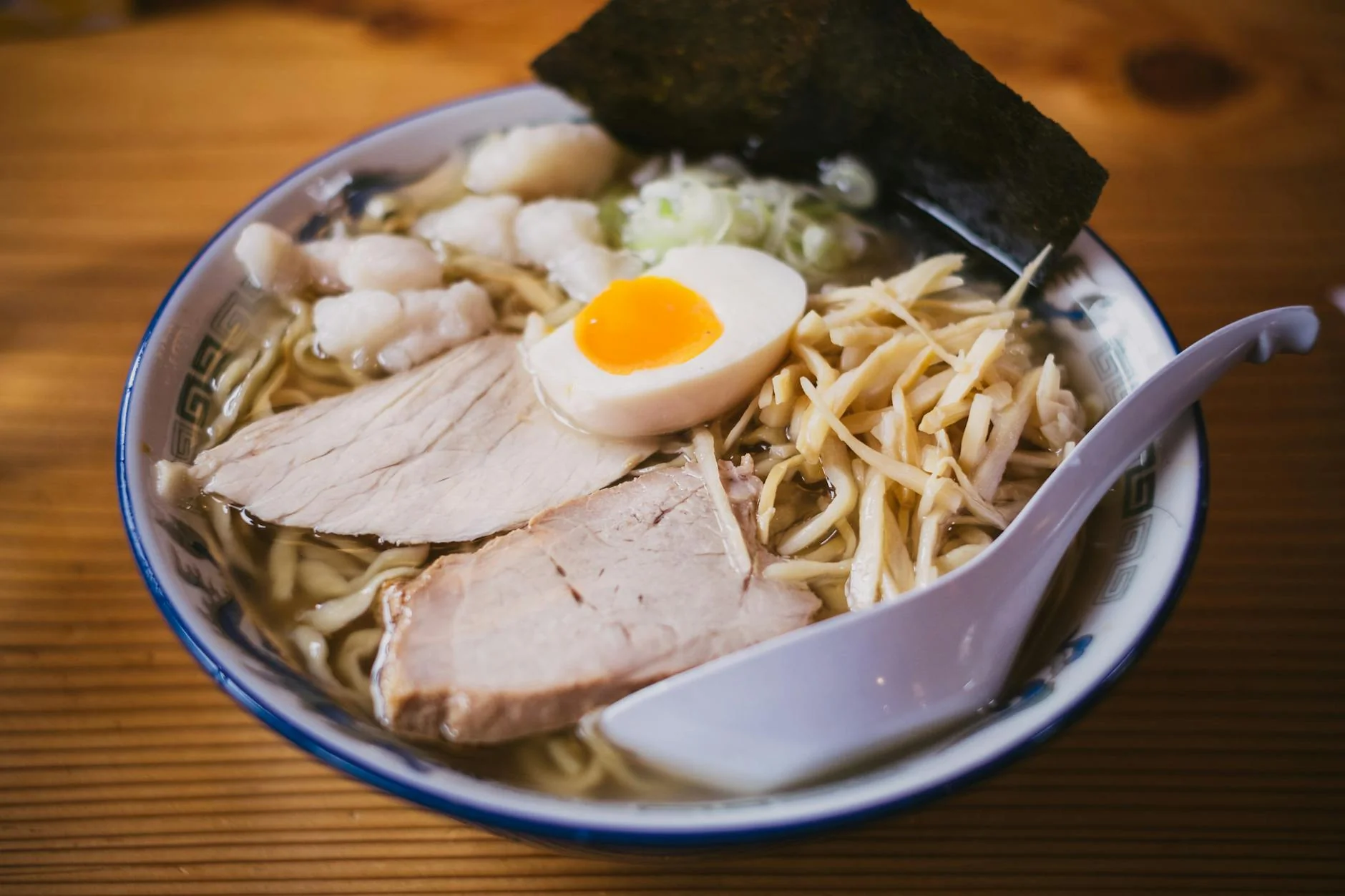 Bol de ramen japonais fumant avec œuf mollet et algue nori
