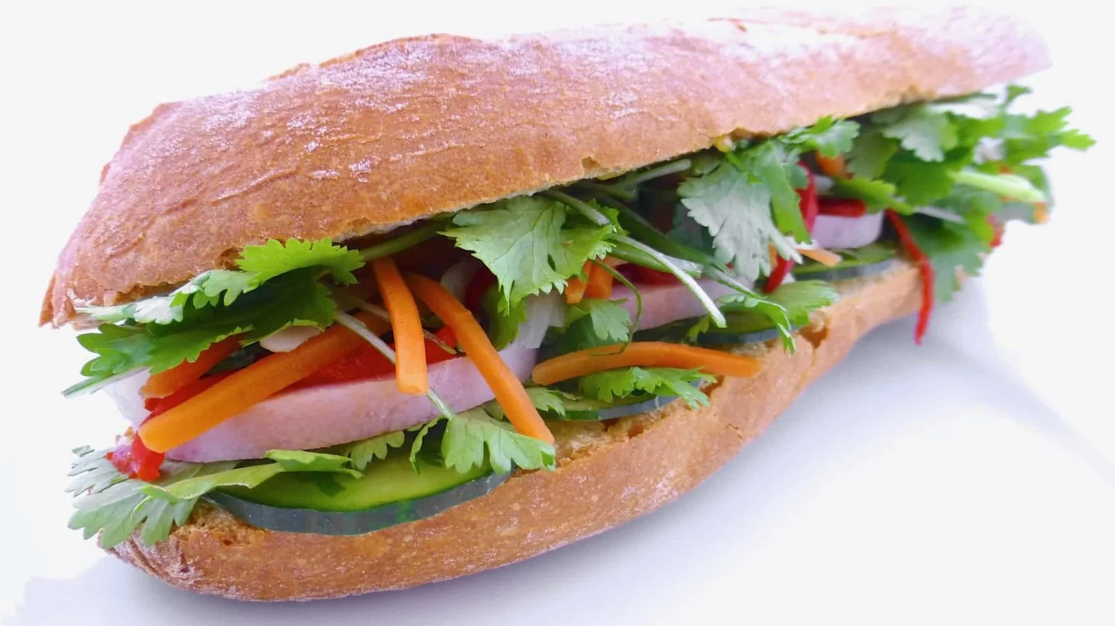 Sandwich Bánh Mì vietnamien croustillant garni de coriandre, piment et carottes