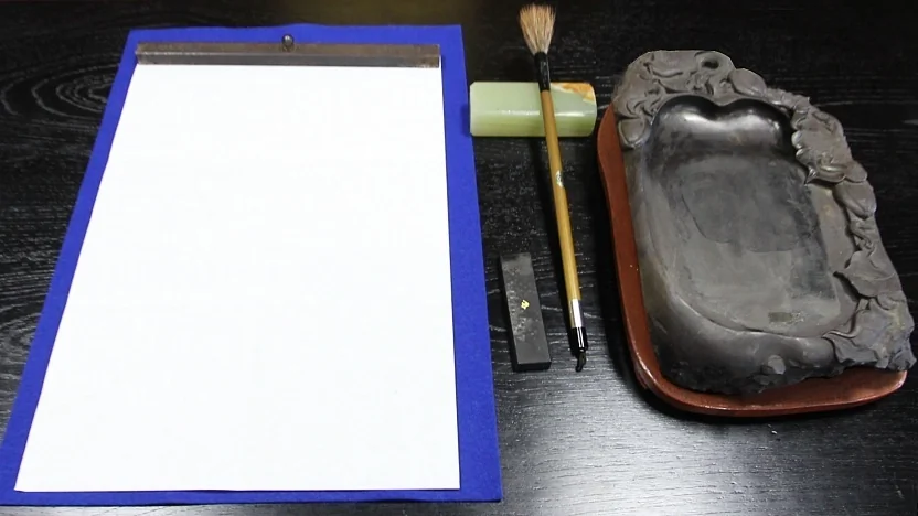 Le matériel traditionnel de calligraphie japonaise incluant le pinceau, l'encre et la pierre