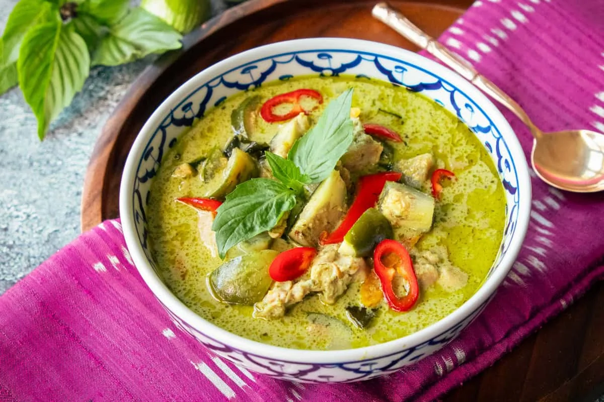 Bol de curry vert thaïlandais authentique avec poulet et basilic frais