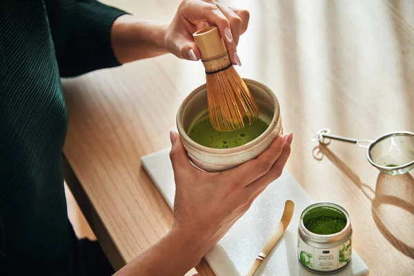 Préparation traditionnelle du thé matcha avec un fouet en bambou