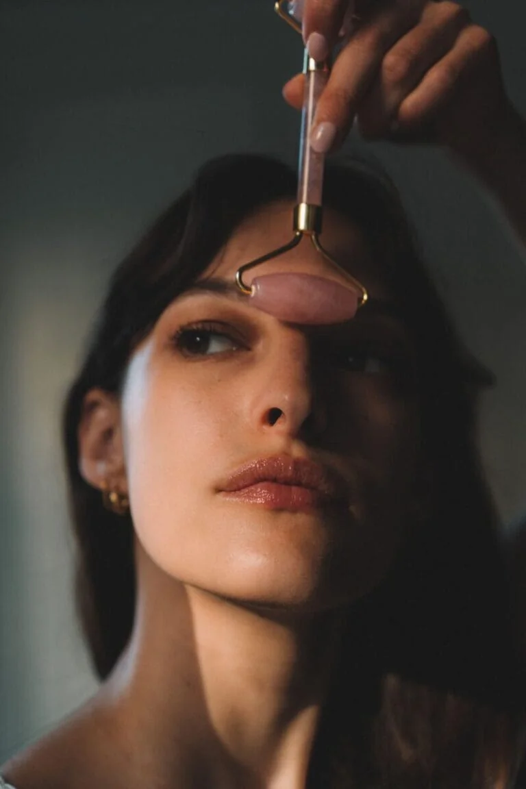 Massage facial avec un roller en quartz rose pour un effet anti-âge