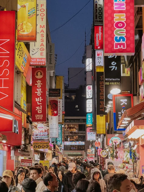 Néons lumineux et rues animées du quartier de Myeongdong la nuit