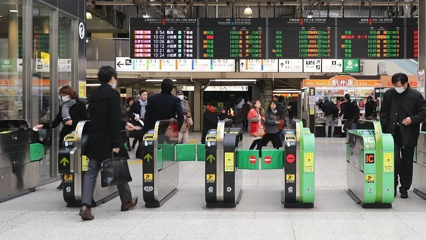Insertion du ticket magnétique dans un portillon automatique au Japon