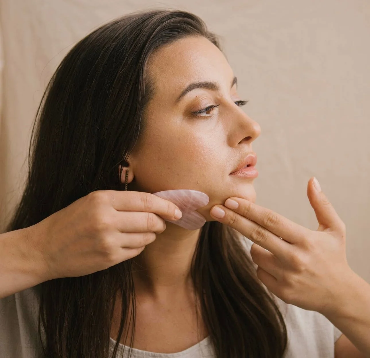 Massage du visage avec un Gua Sha après le double nettoyage coréen