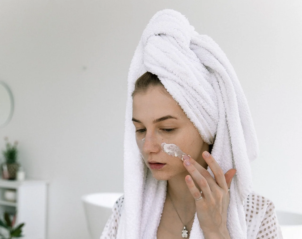 Femme appliquant une huile démaquillante sur son visage pour le double nettoyage