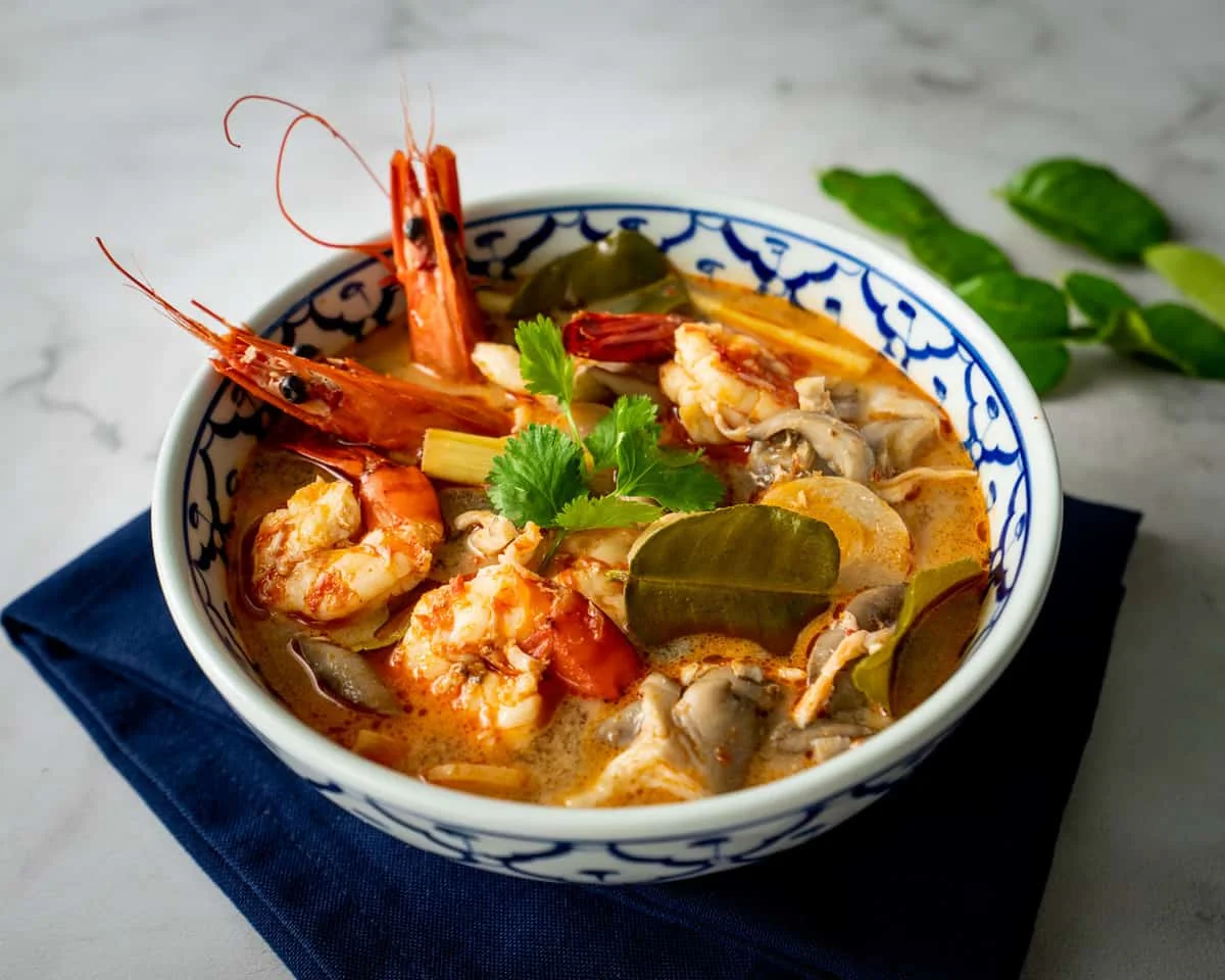Soupe Tom Yum Goong servie dans un bol traditionnel avec crevettes et herbes fraîches