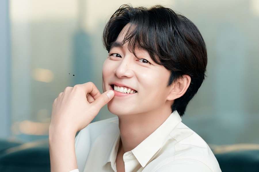 Gong Yoo en costume de recruteur face caméra, visuel rétrospectif de sa carrière.